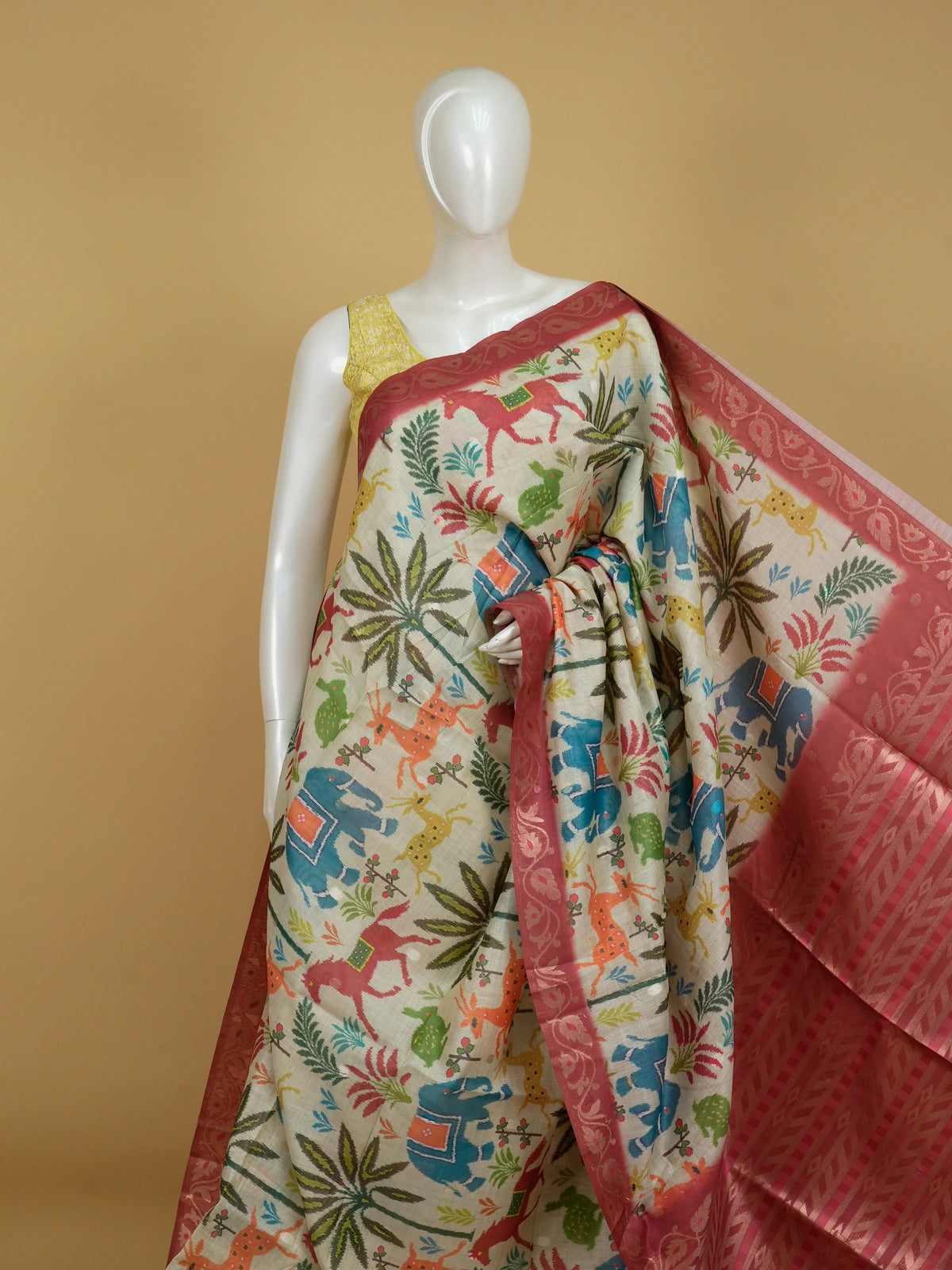 Cream linen cotton saree with multicolour Patola-style animal print and contrast red zari border