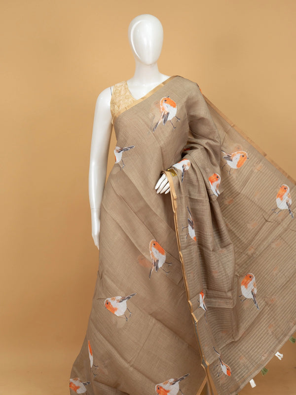 Beige linen cotton saree with orange robin bird prints and a golden zari border