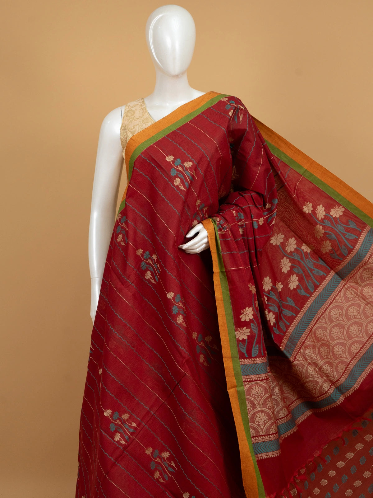Maroon red silk cotton saree with orange contrast border, floral woven motifs and decorative pallu