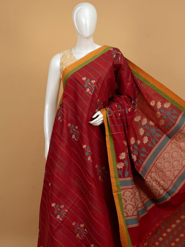 Maroon red silk cotton saree with orange contrast border, floral woven motifs and decorative pallu