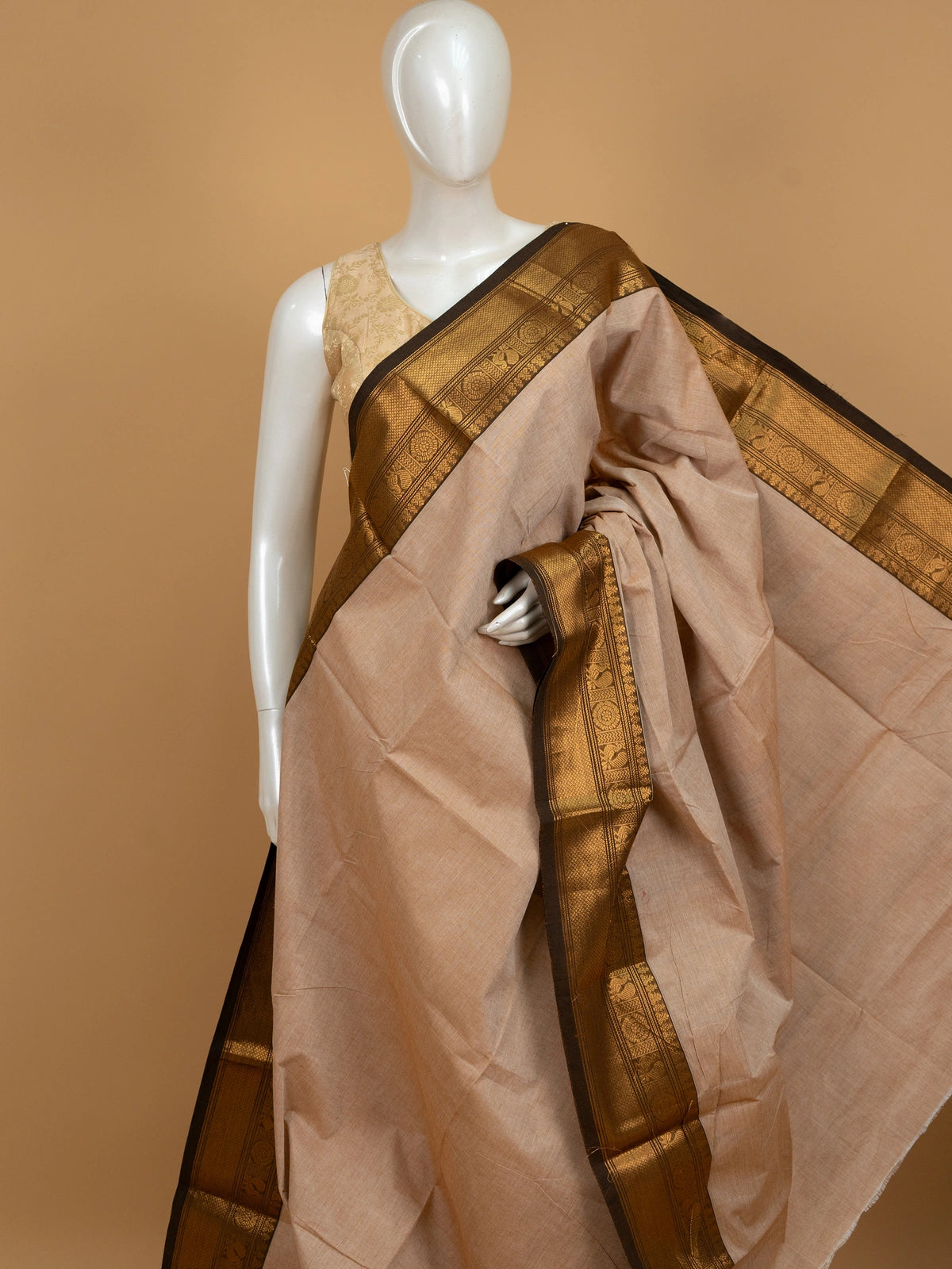 Beige Chettinad cotton saree with dark brown and gold zari peacock motif border