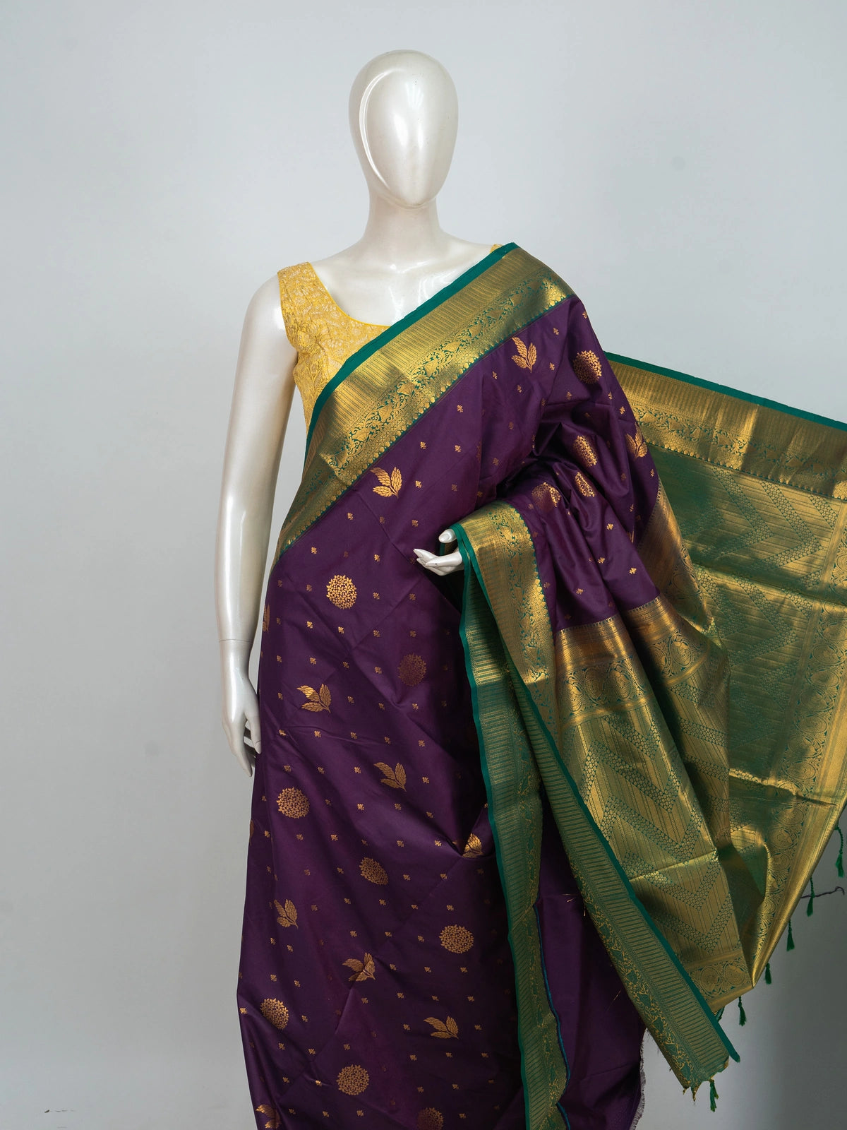 Purple semi silk saree with gold zari butta, contrast green zari border and ornate green-gold pallu