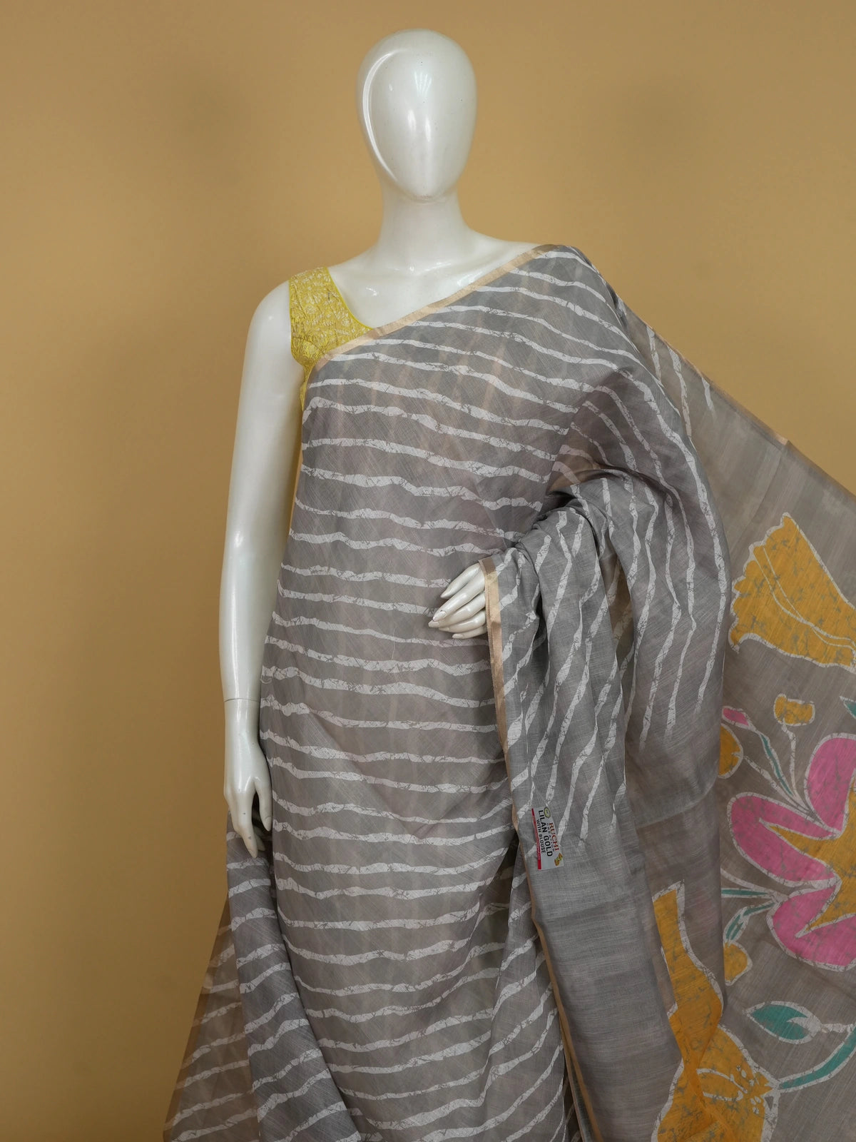 Grey linen cotton saree with white diagonal leheriya stripes, gold zari border and a floral batik pallu