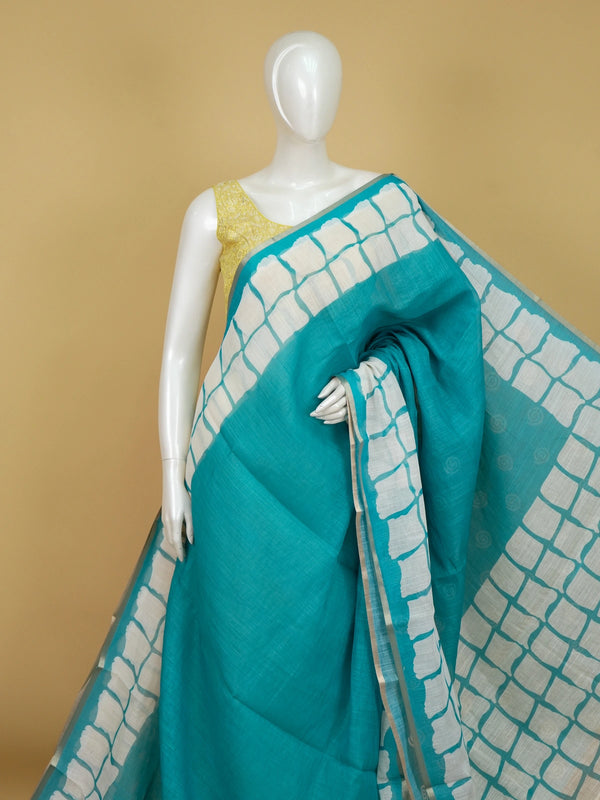 Teal and off-white linen cotton saree with batik grid border and white spiral motifs