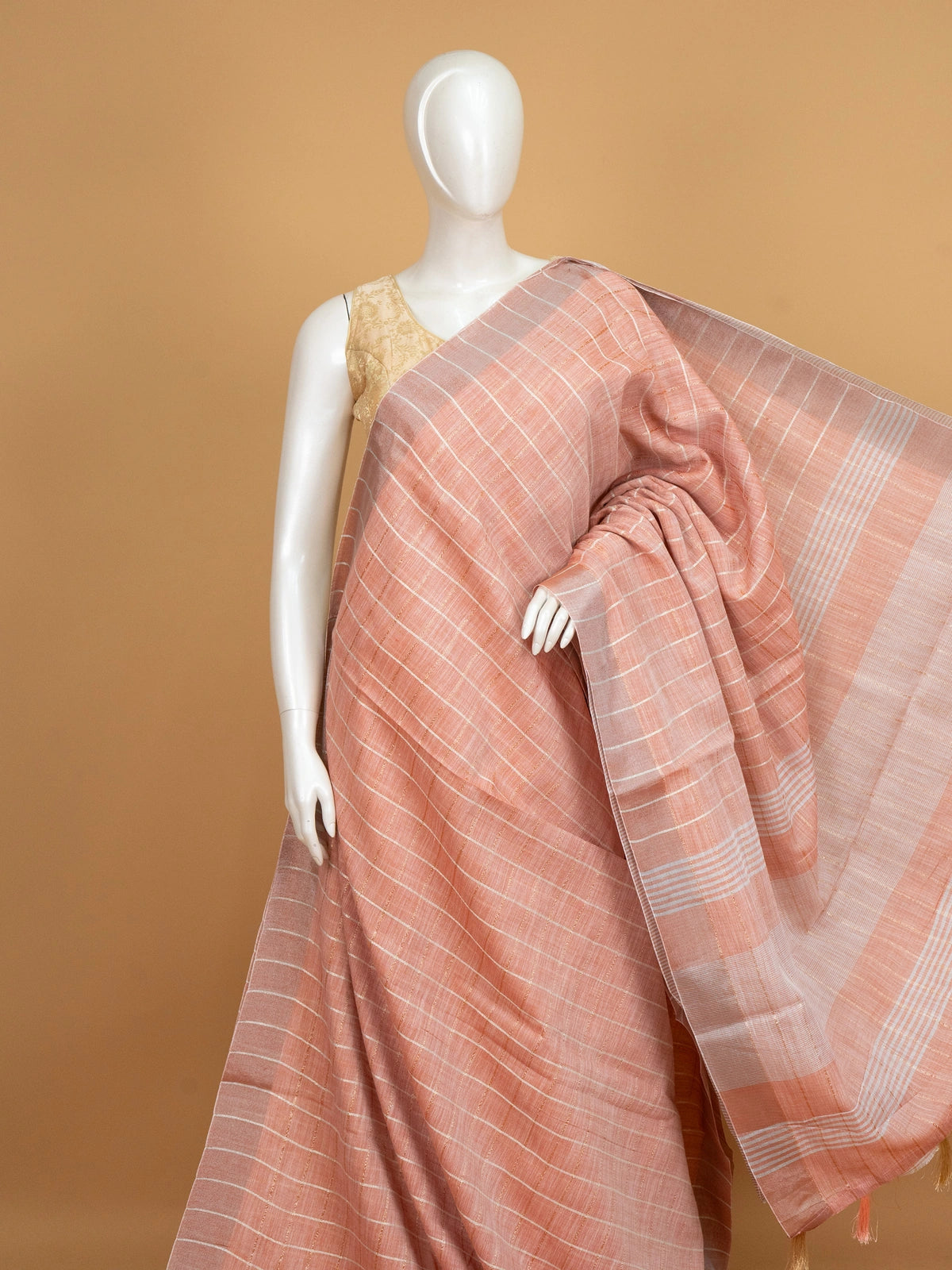 Peach linen cotton saree with white and gold zari checks and contrast striped border