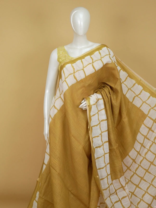 Mustard and white batik print linen cotton saree with contrast tile border and spiral motifs