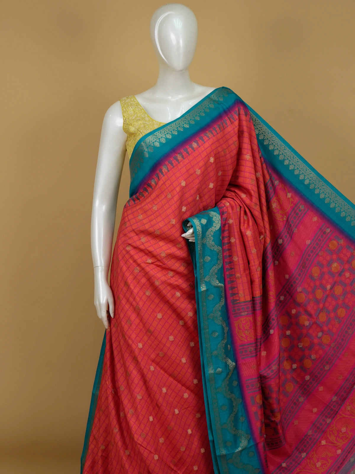 Coral red Dola silk saree with pink checks, gold zari buttas and a contrast teal blue zari border