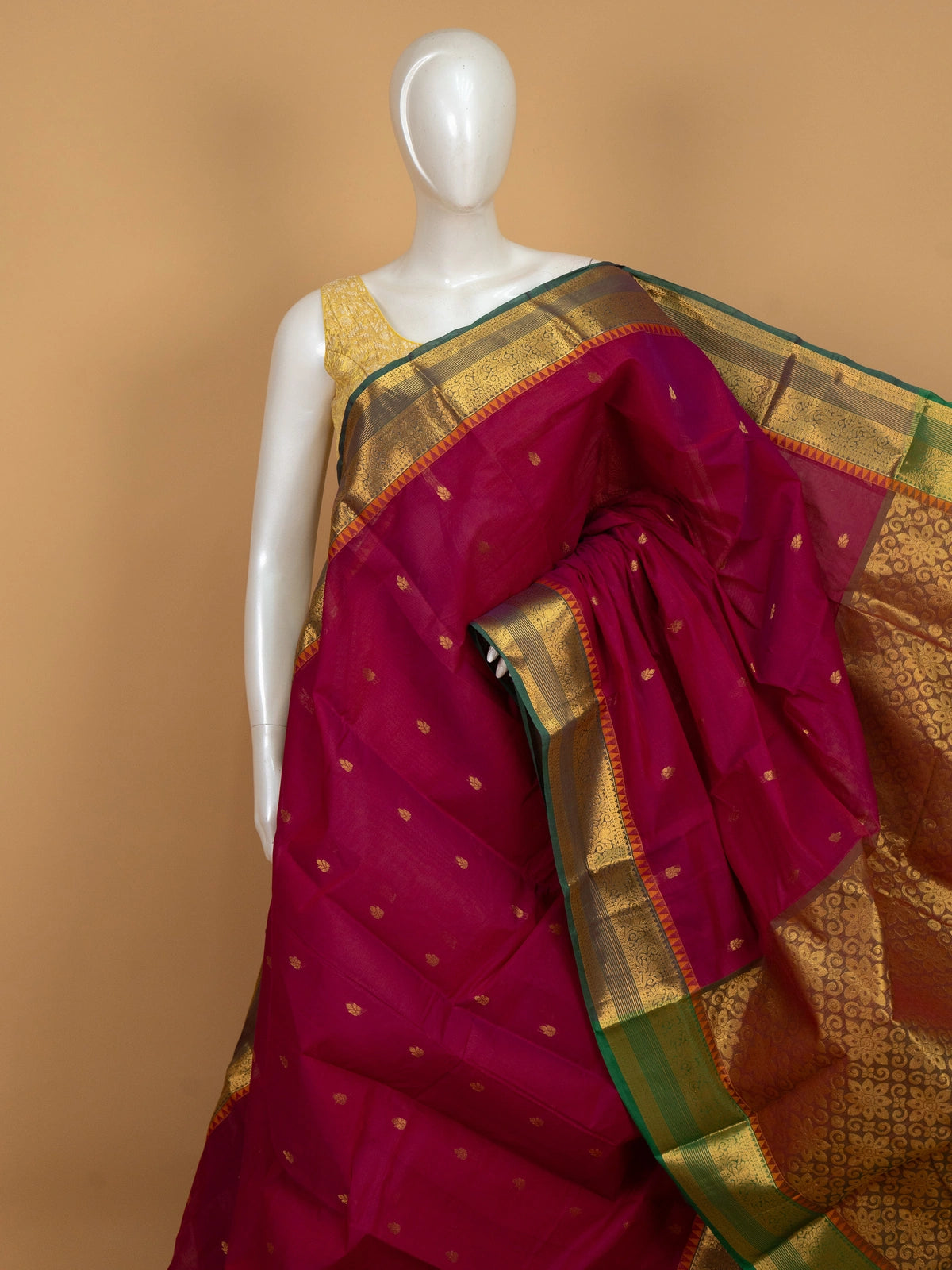 Pink Chettinad cotton saree with contrast green-and-gold zari border, gold buttas, and ornate gold pallu