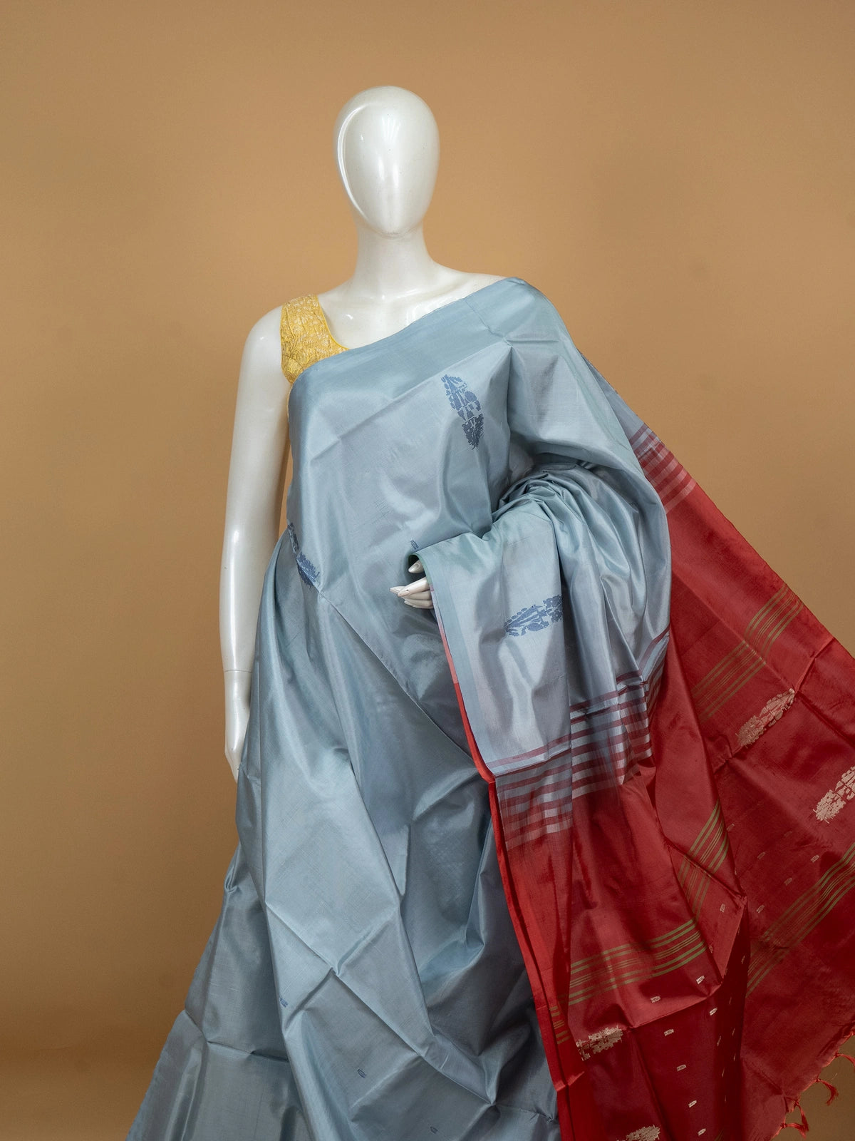 Grey-blue Banana Silk saree with blue buta motifs and a contrast red pallu with gold zari stripes