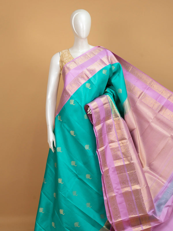 Teal green pure Kanchipuram silk saree with lavender contrast border and gold zari buttas