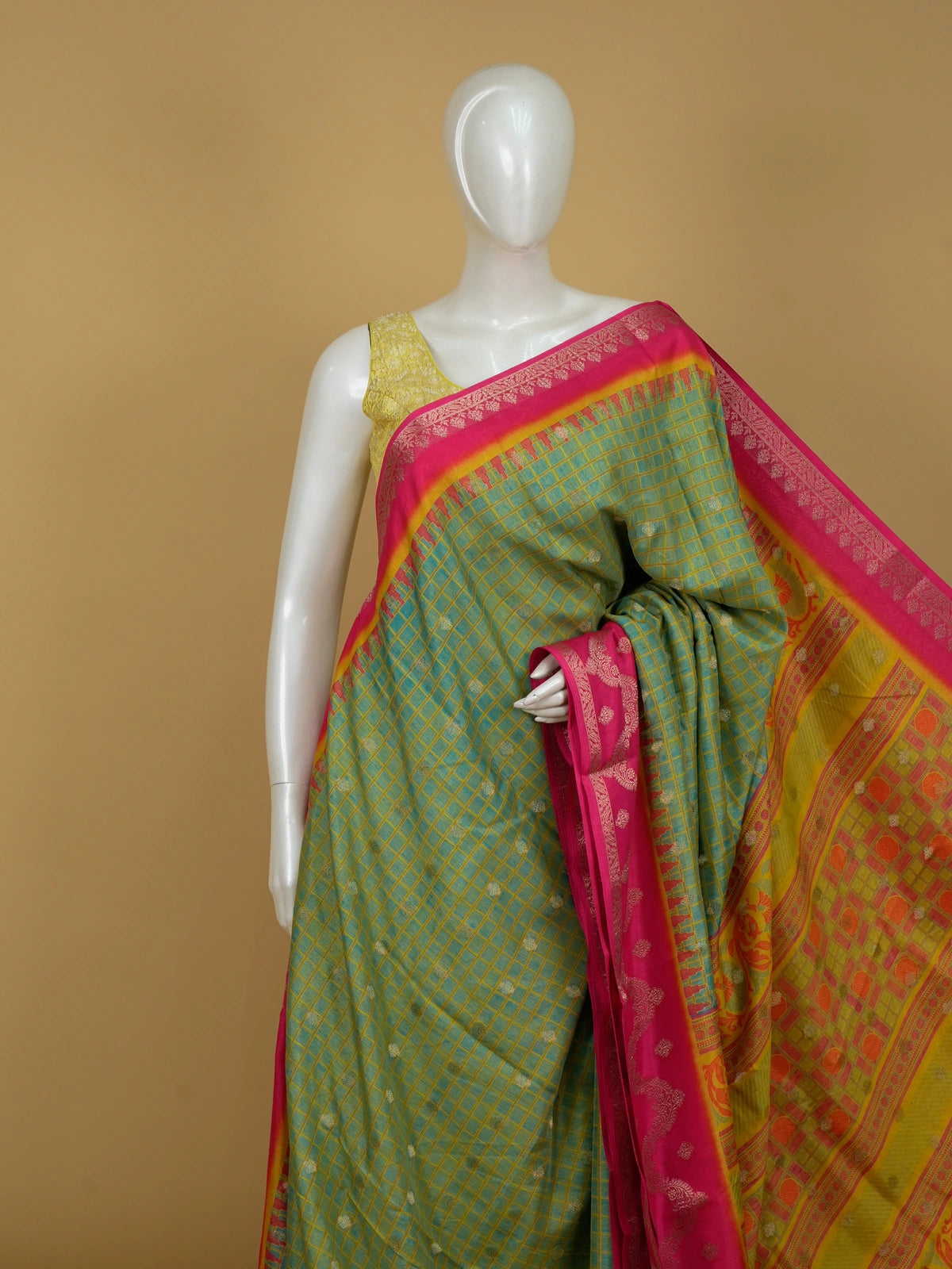 Green Dola silk saree with golden checks, contrast pink zari border and ornate orange-yellow pallu