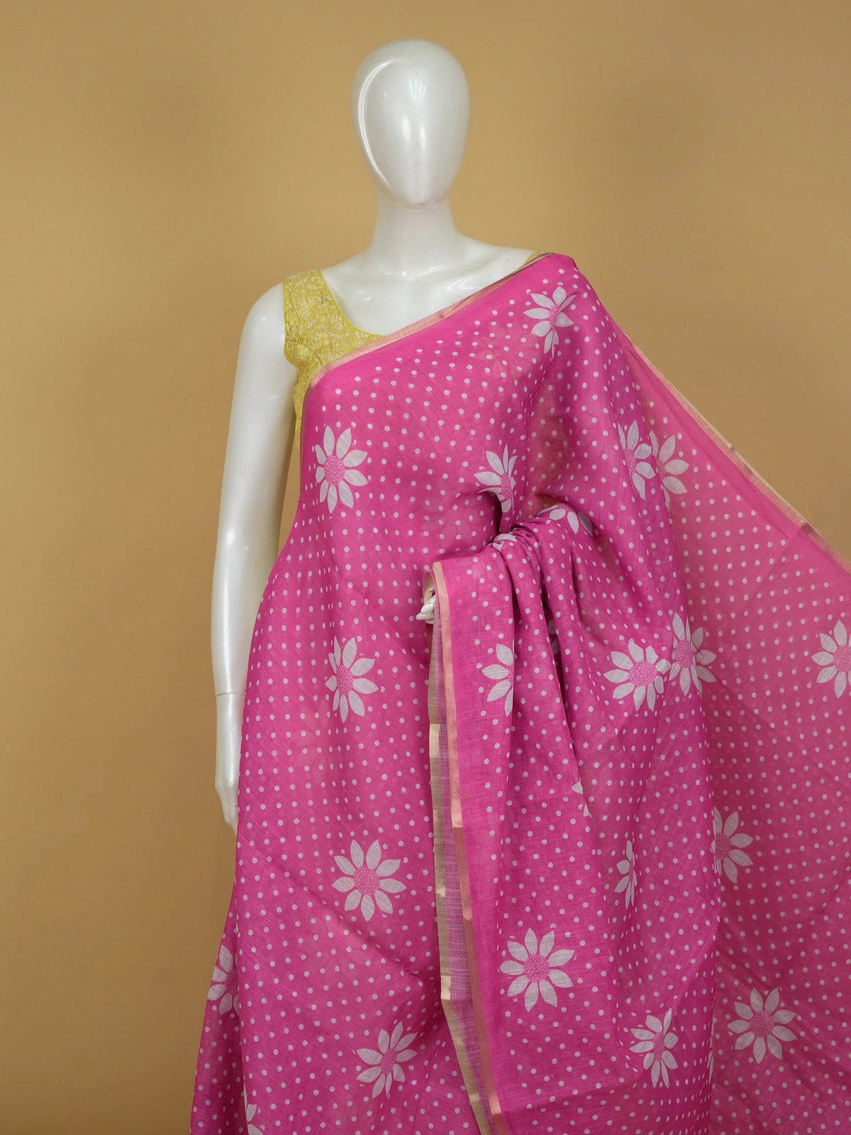 Pink linen cotton saree with white polka dots, floral motifs and a gold zari border