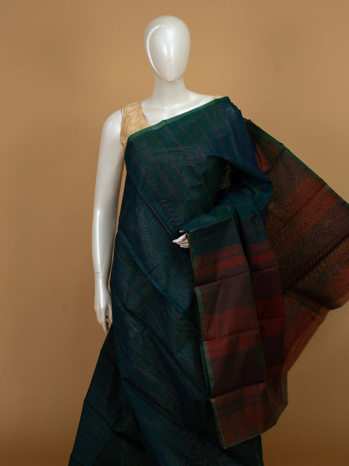 Teal green silk cotton saree with maroon stripes and contrast striped pallu on mannequin