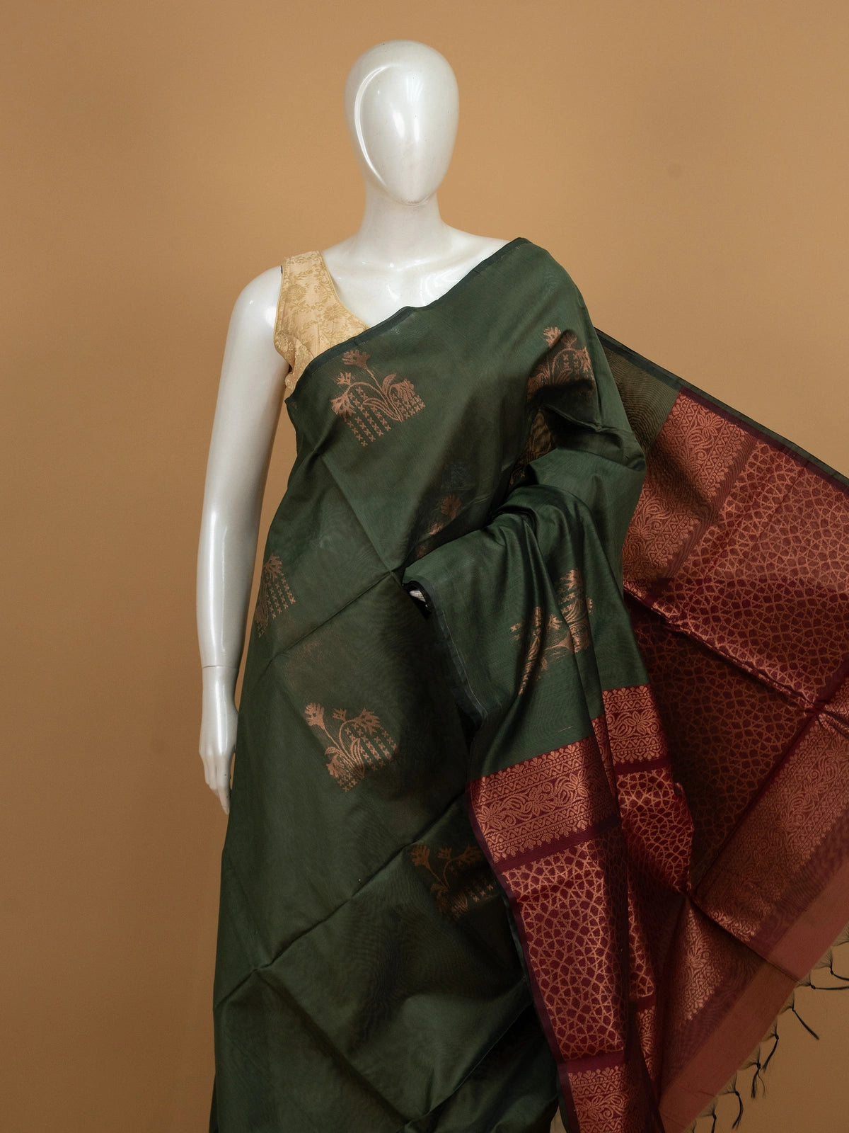 Dark green silk cotton saree with copper zari buttas and contrast maroon border and pallu