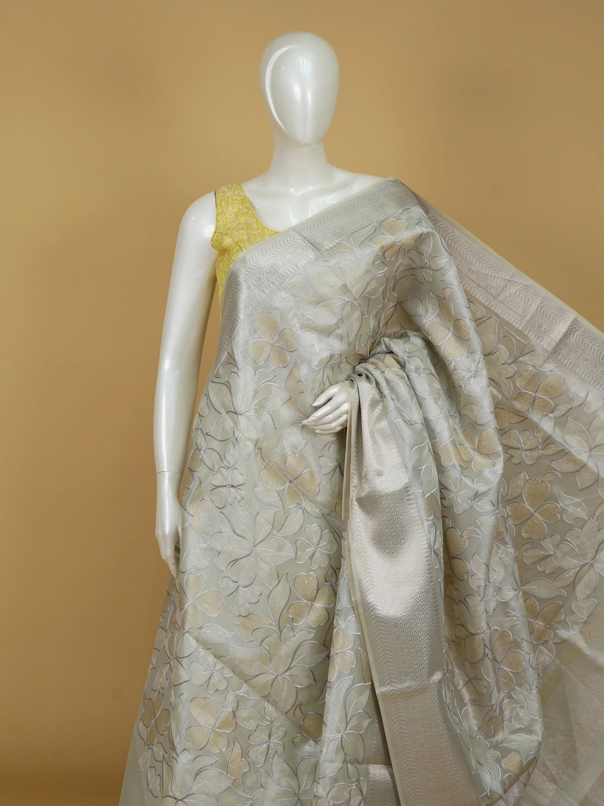 Pastel grey-green organza designer saree with floral embroidery and silver zari border