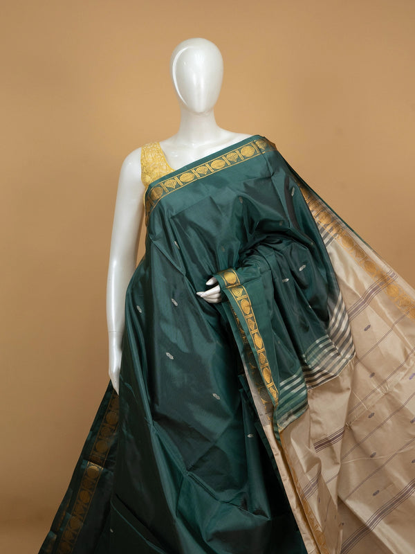 Bottle green banana silk saree with gold zari border and contrast cream striped pallu