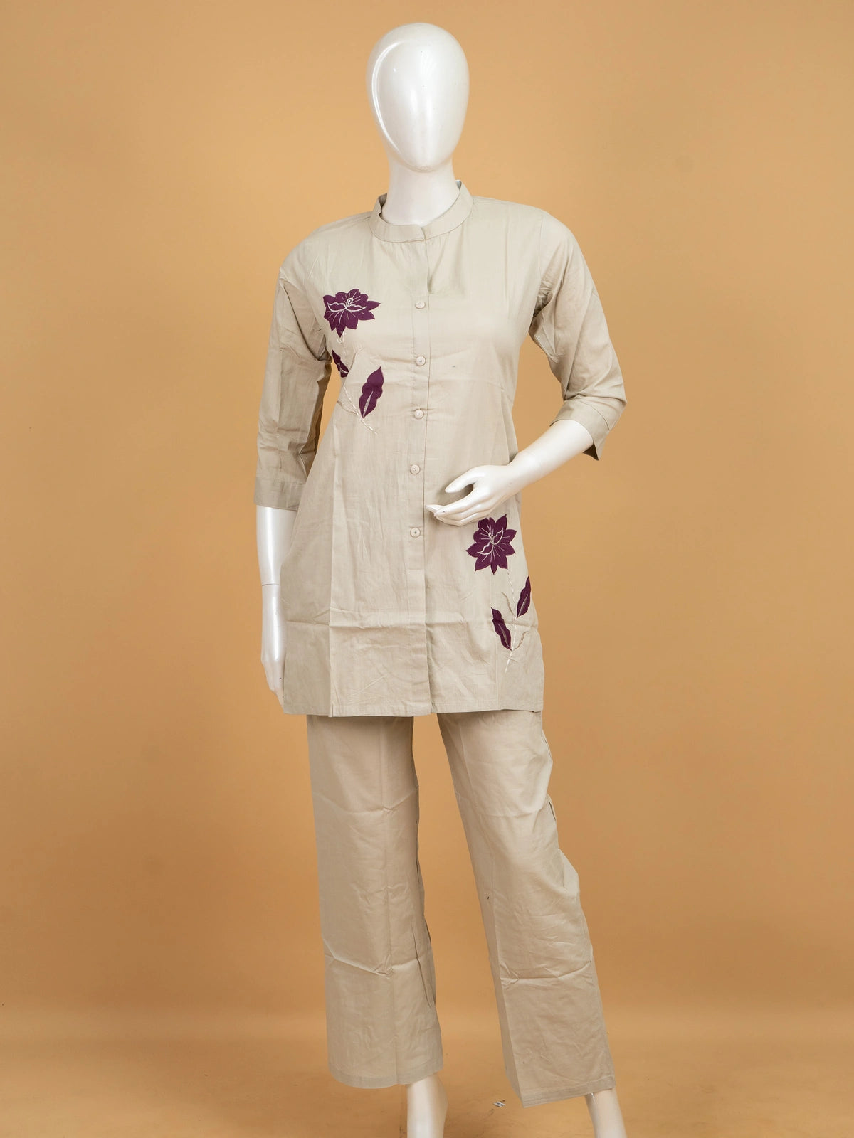 Beige cotton co-ord kurti set with purple floral appliqué motifs and matching straight pants