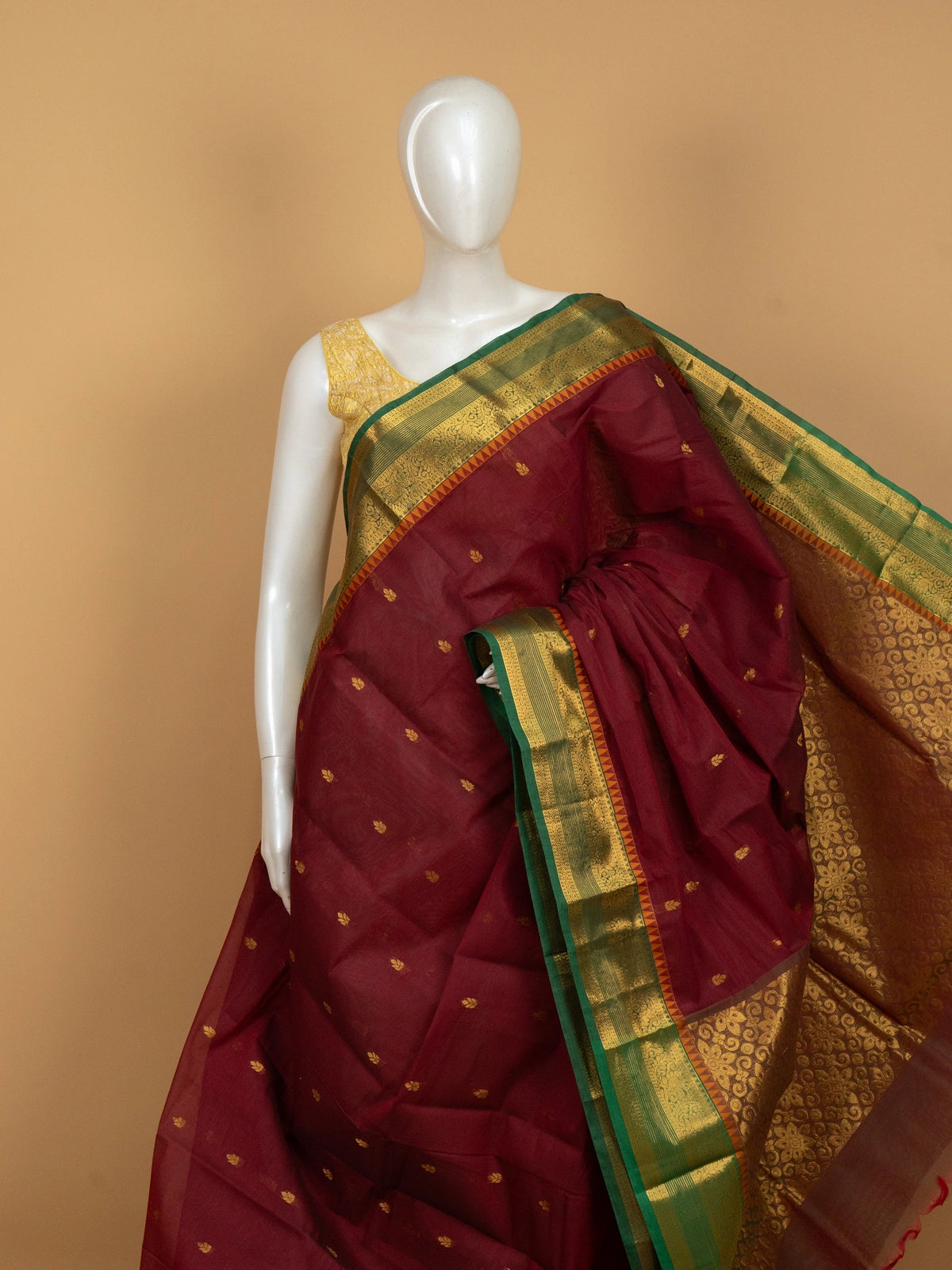 Maroon Chettinad cotton saree with green and gold zari contrast border and gold buttas
