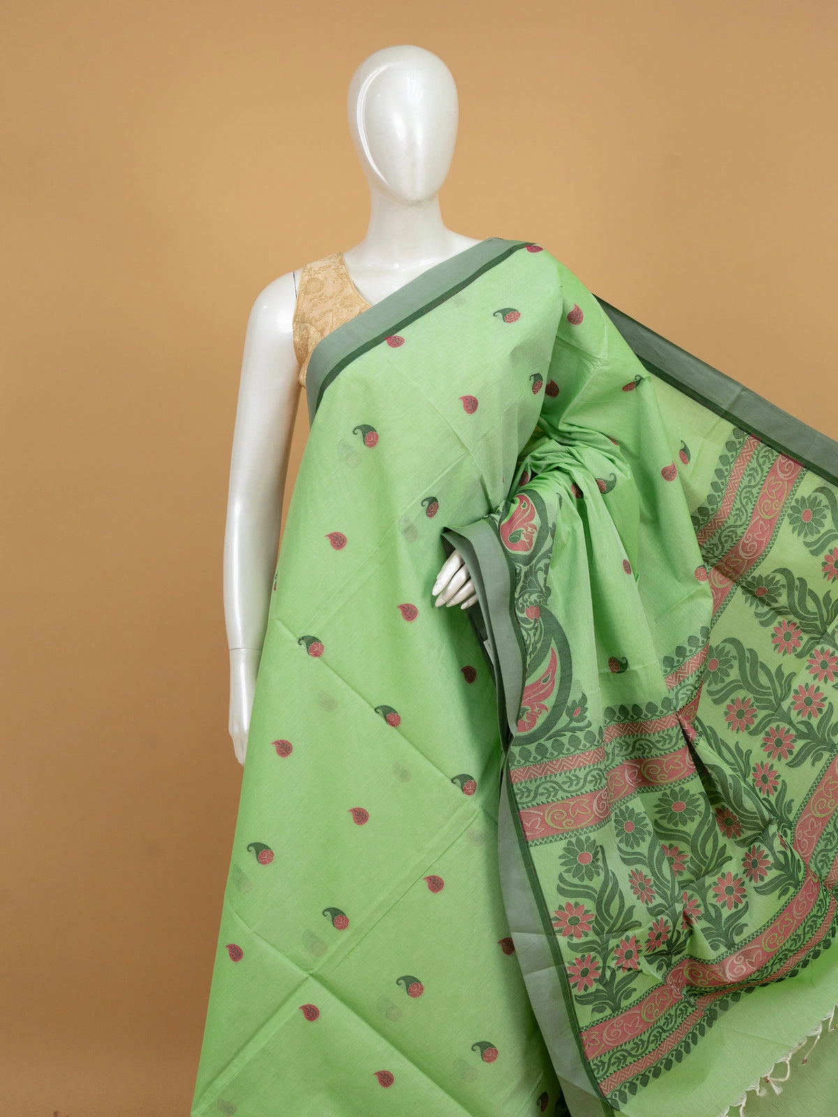 Light green silk cotton saree with pink paisley buttas, contrast grey-green border, and woven floral pallu