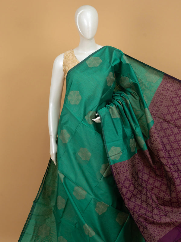 Teal green silk cotton saree with cream floral buttas and contrast purple woven border and pallu