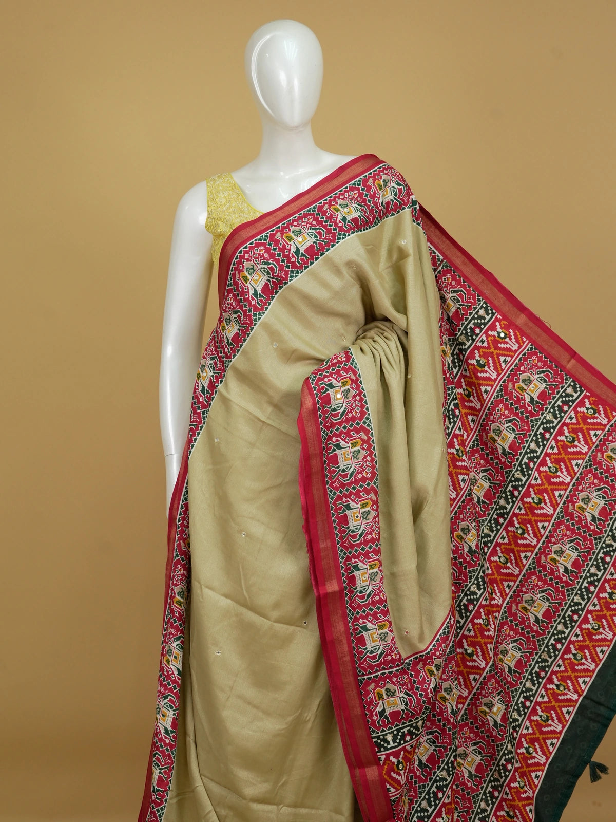 Beige linen cotton saree with red patola-print elephant motif border and pallu