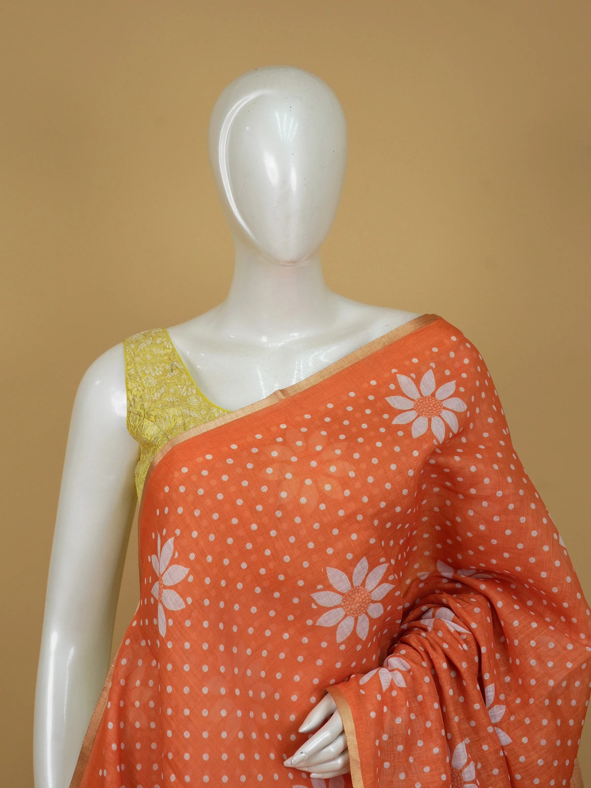 Orange linen cotton saree with white polka dots, floral motifs and a thin gold border