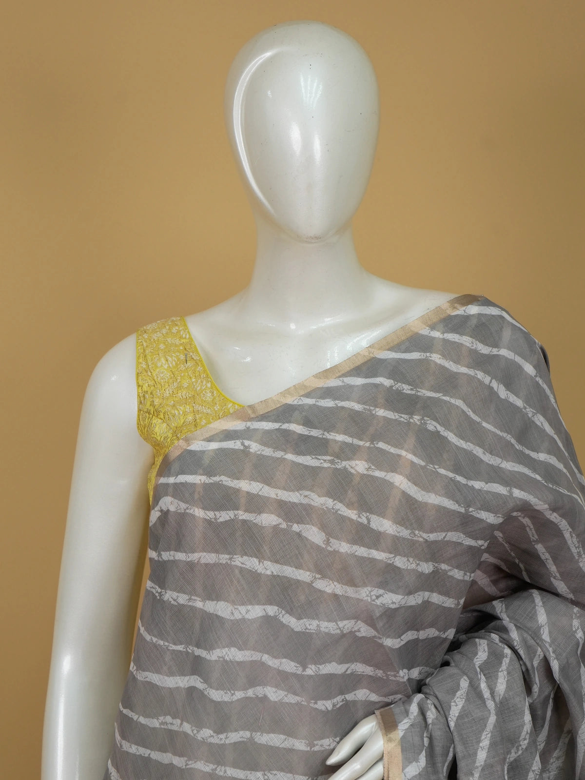 Grey linen cotton saree with white diagonal leheriya stripes, gold zari border and a floral batik pallu