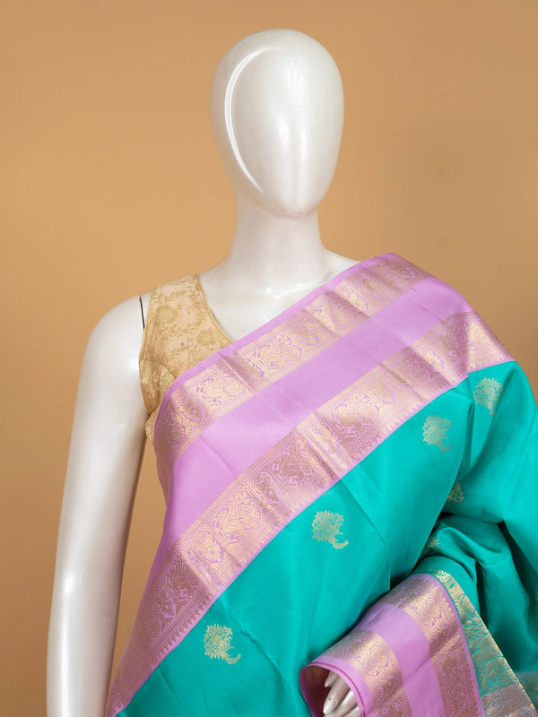 Teal green pure Kanchipuram silk saree with lavender contrast border and gold zari buttas