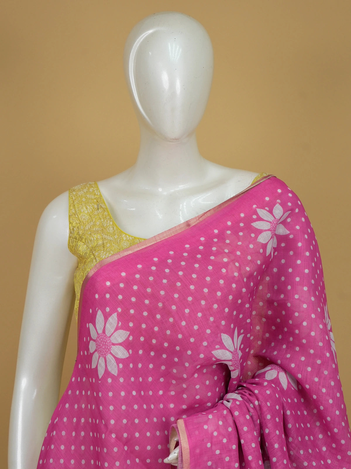 Pink linen cotton saree with white polka dots, floral motifs and a gold zari border