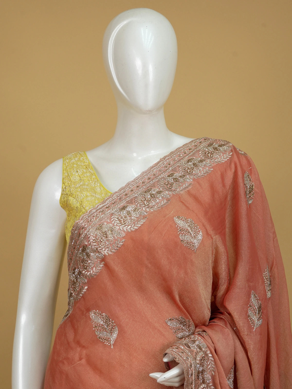 Peach shimmer tissue designer saree with embroidered leaf buttas and an ornate rose-gold border