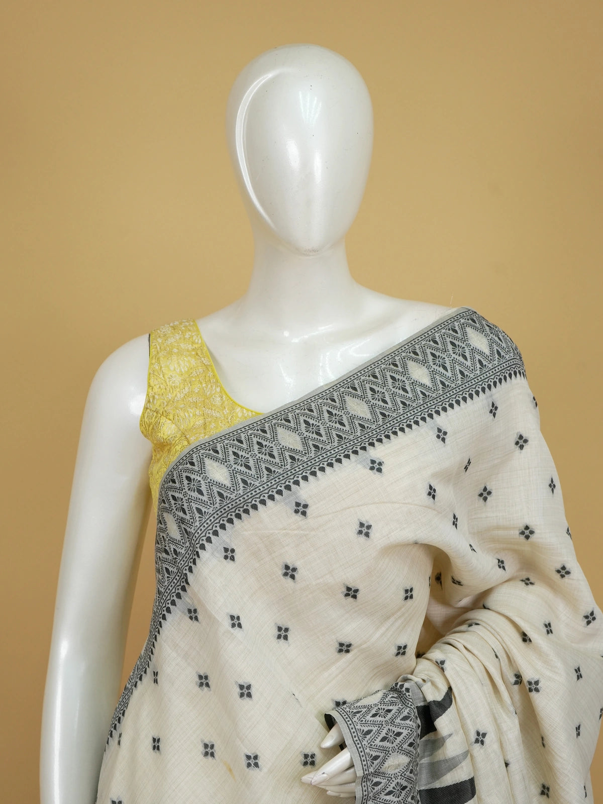 Ivory linen cotton saree with black temple border, floral buttas and pink patterned pallu