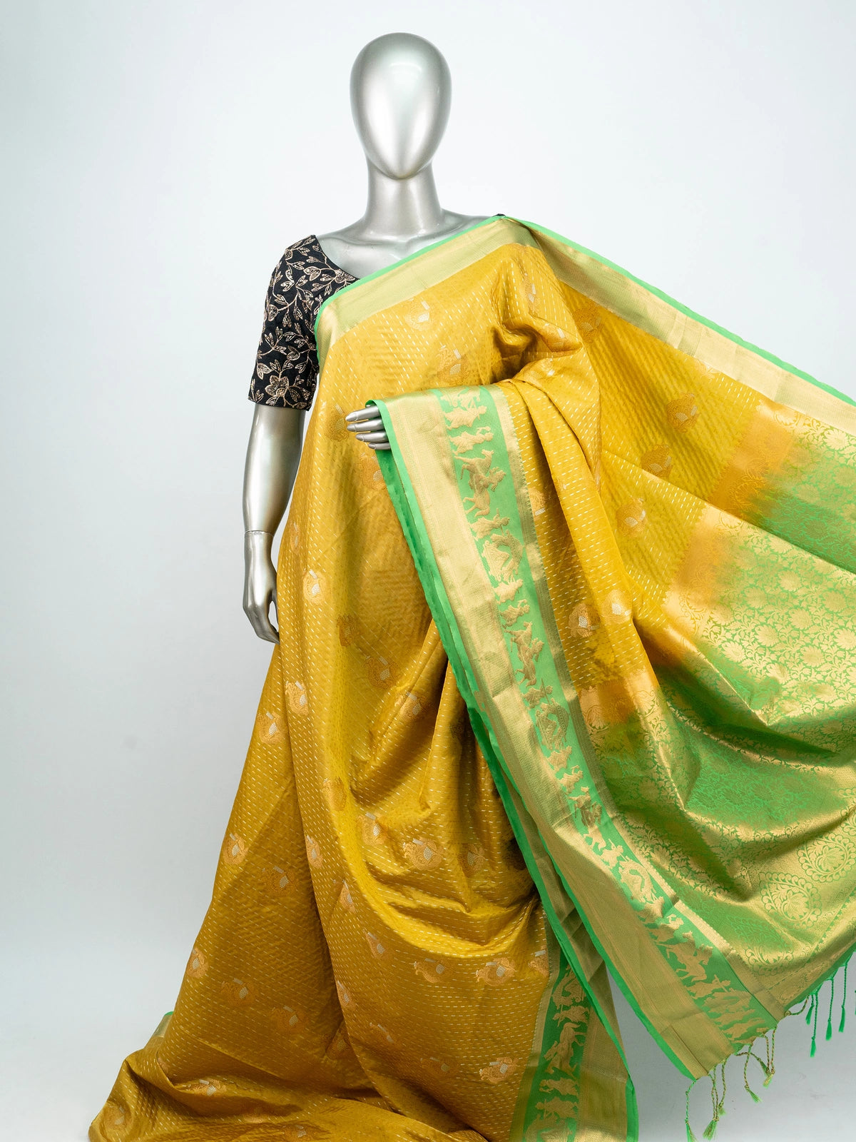 Mustard yellow soft silk saree with contrast green gold zari border and floral motif pallu