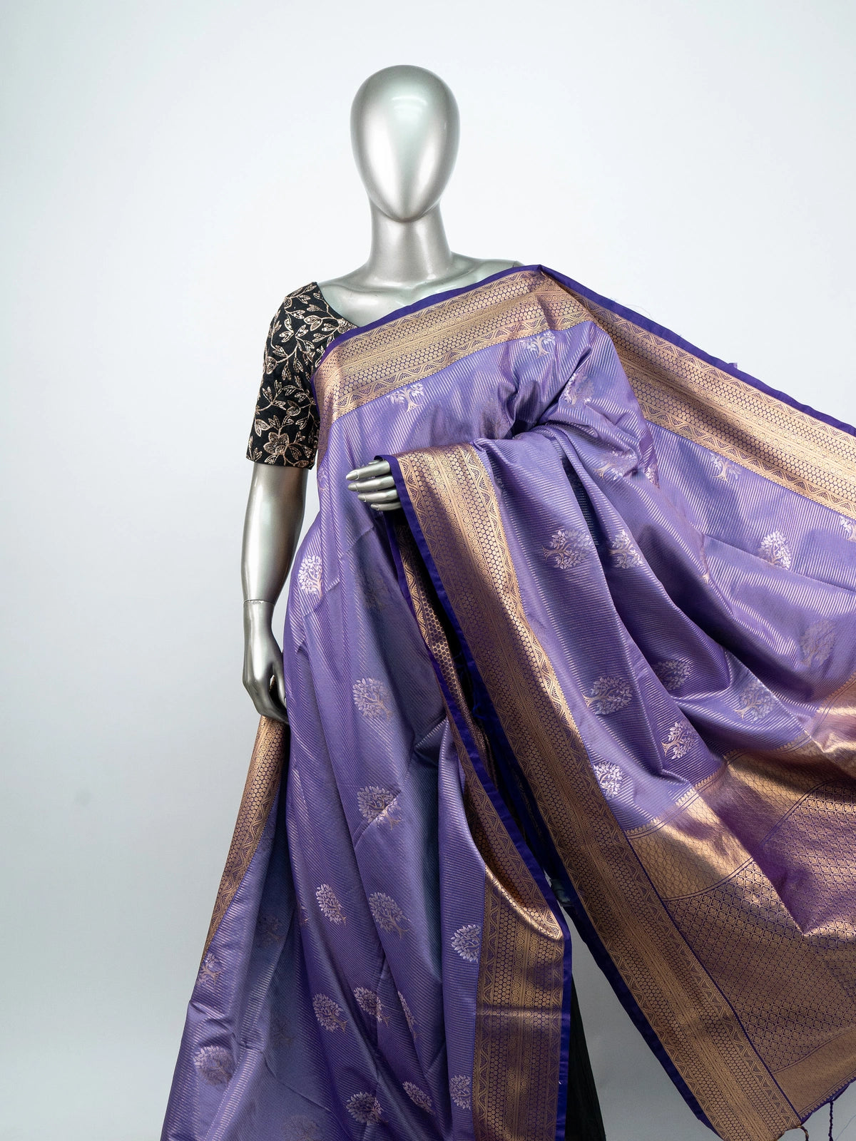 Lavender soft silk saree with gold zari tree motifs, navy blue pallu and black embroidered blouse