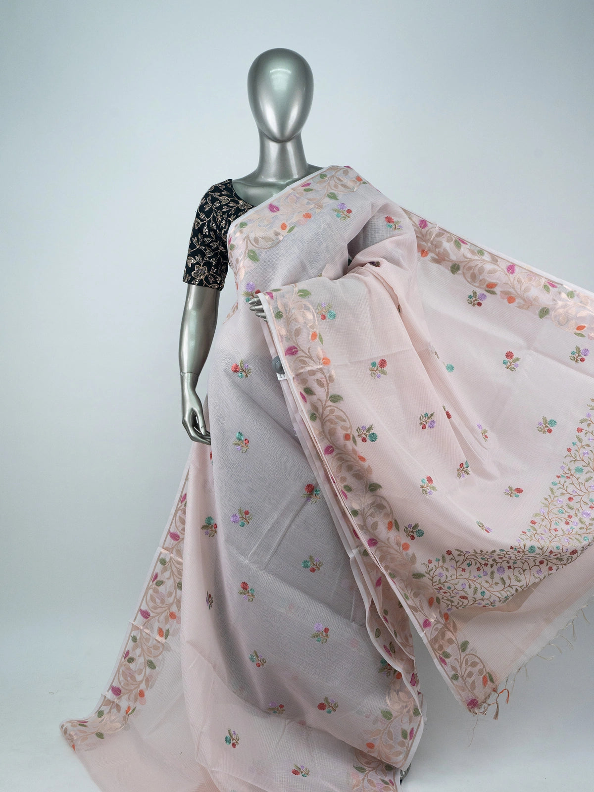 Blush pink linen cotton saree with multicolour floral buttas, gold zari floral border and contrast black embroidered blouse