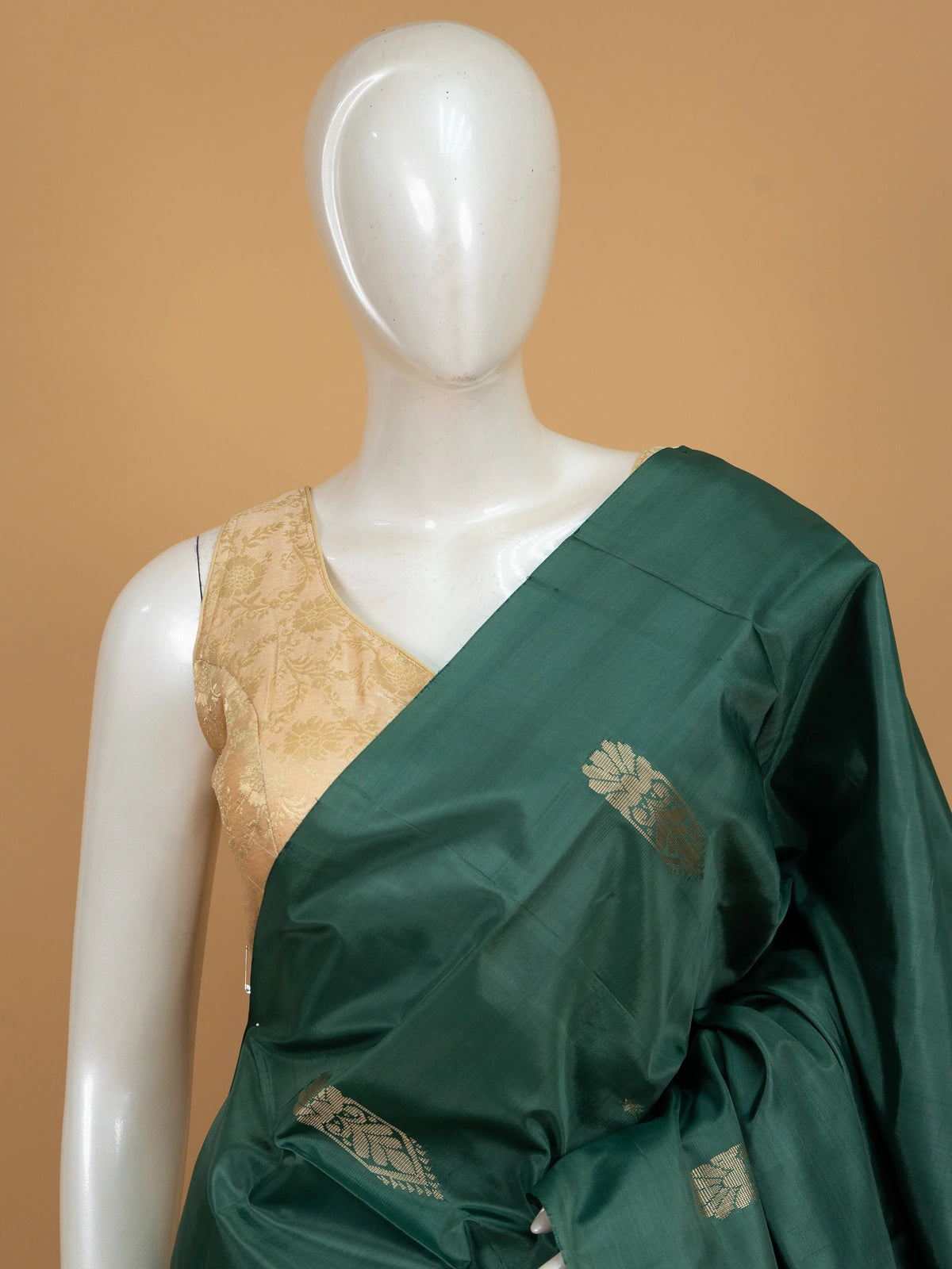 Bottle green banana silk saree with gold zari buttas and contrast peach striped pallu