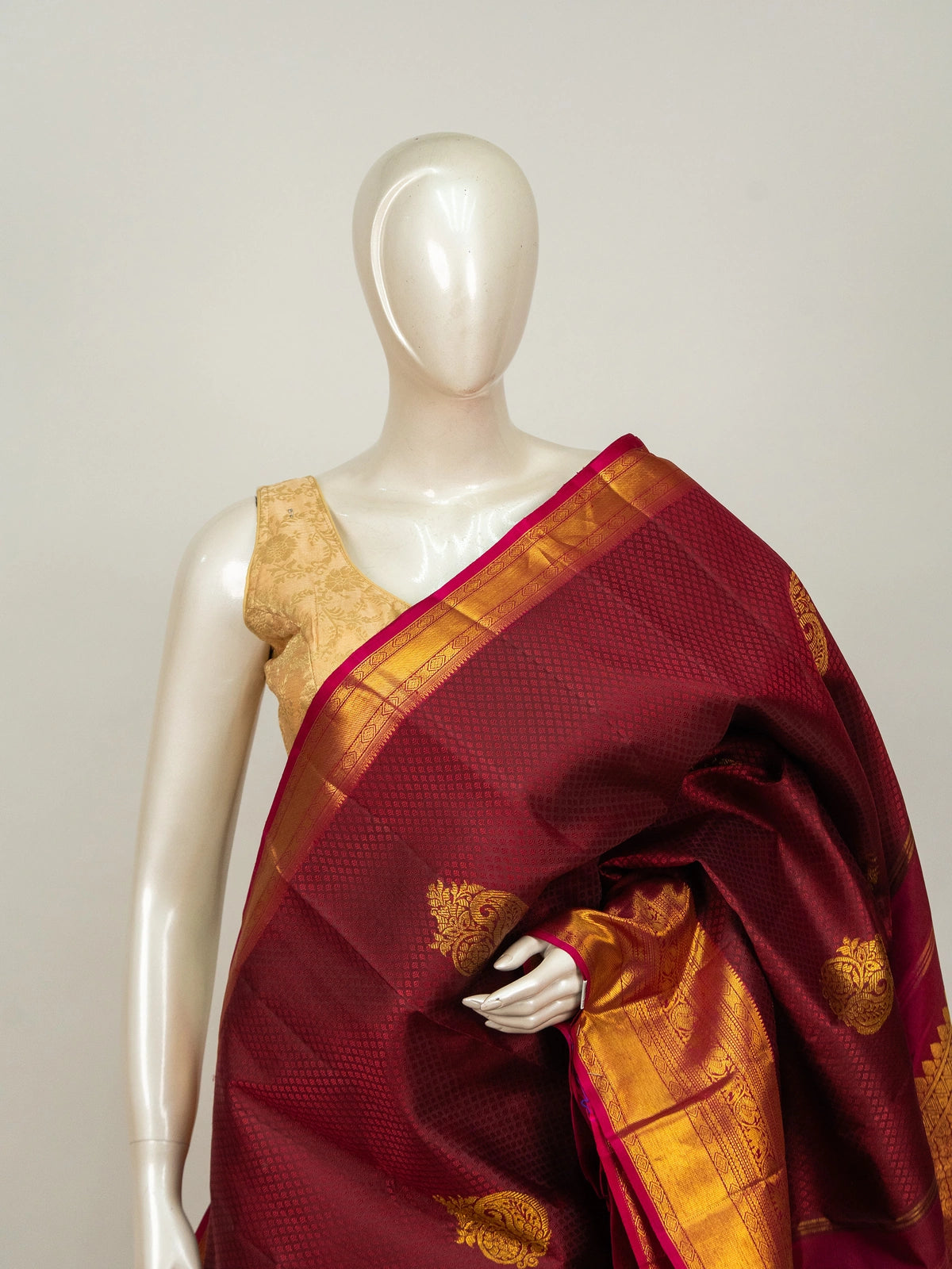 Maroon pure Kanchipuram silk saree with contrast pink and gold zari border and paisley buttas