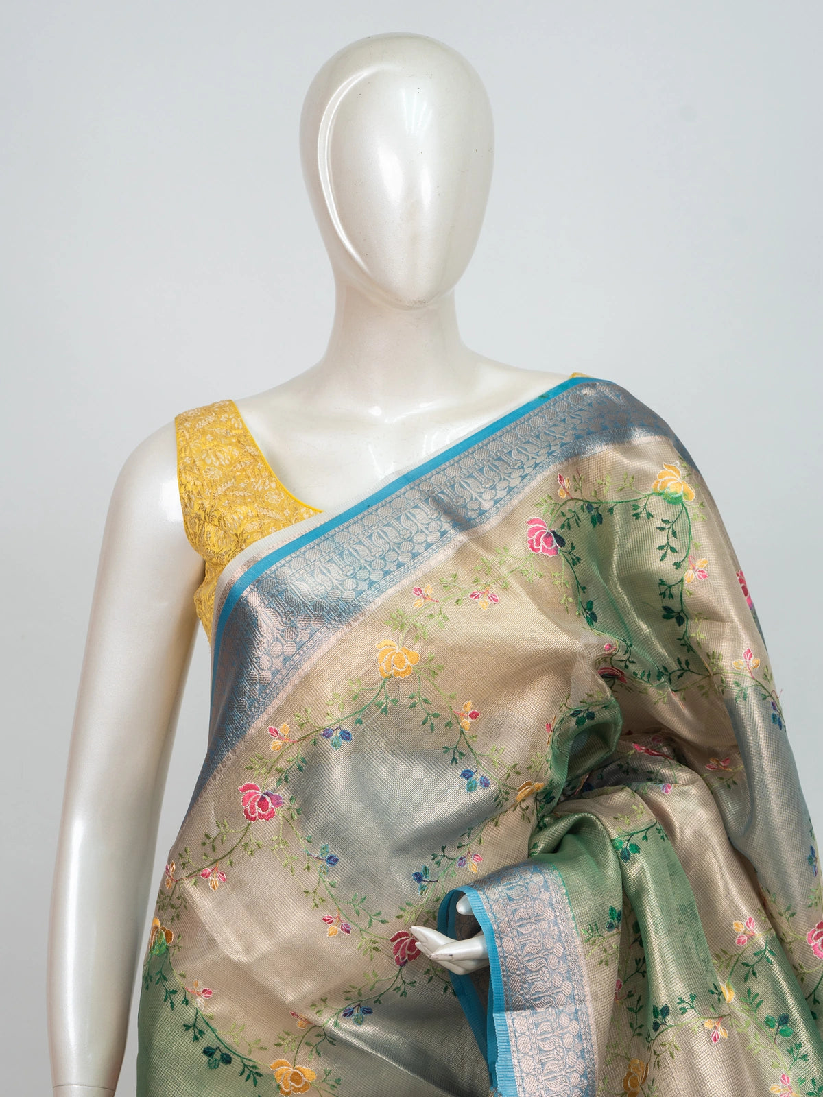 Beige and teal blue semi raw silk saree with multicoloured floral embroidery and silver zari border