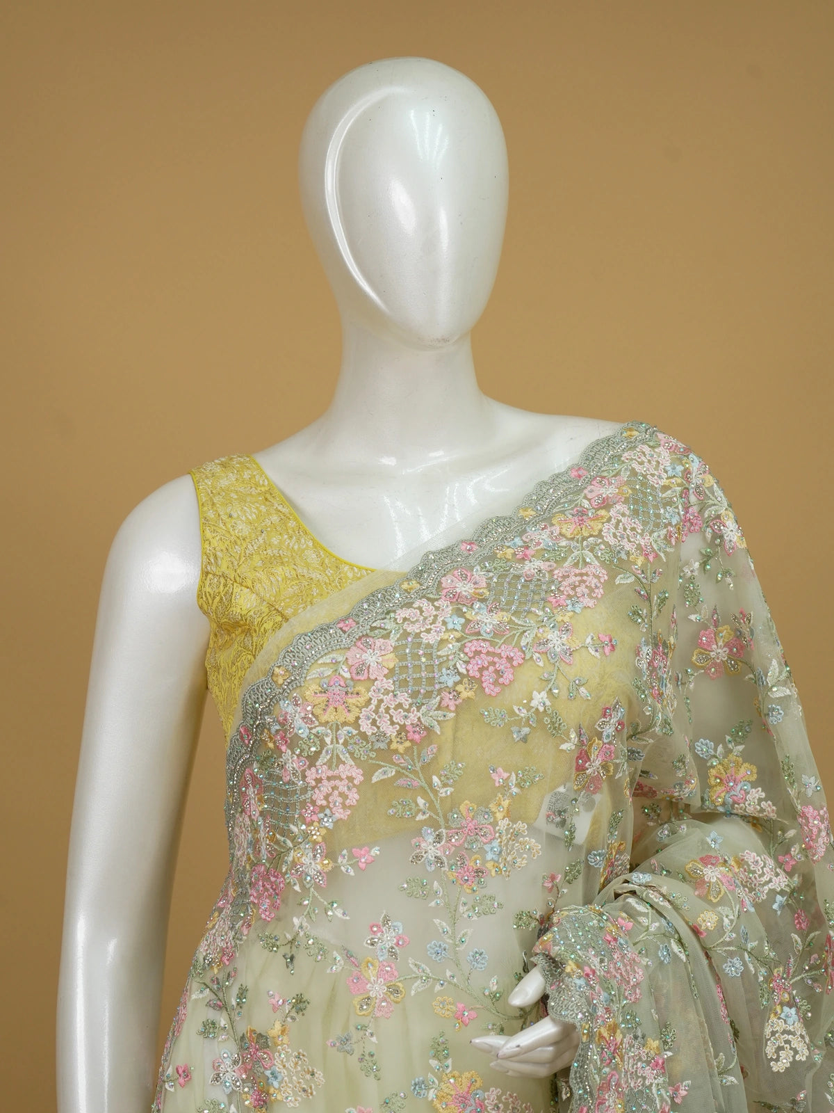 Pastel lemon-green designer net saree with multicolour floral embroidery and scalloped sequin border