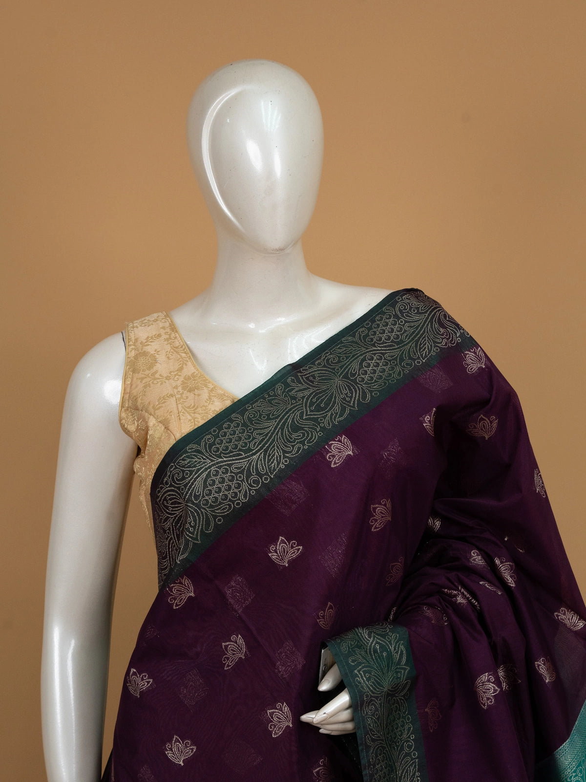 Purple silk cotton saree with teal-green contrast border and gold zari lotus motifs
