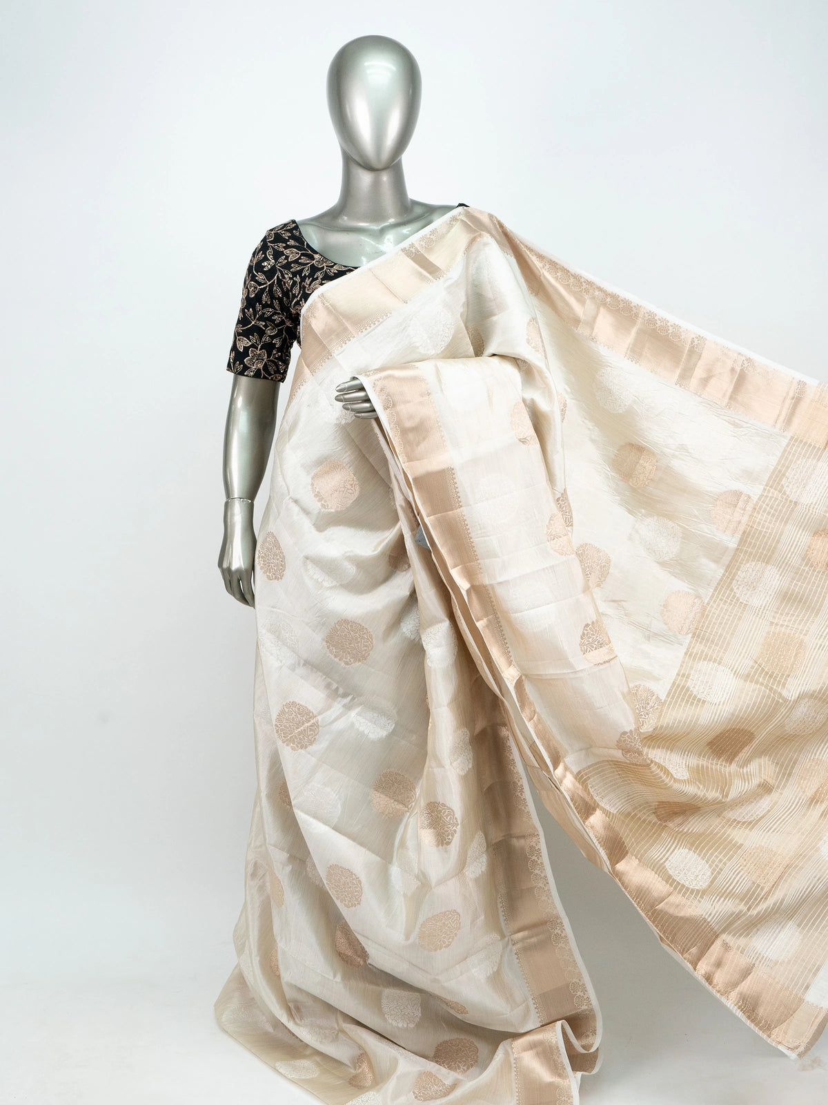 Cream semi raw silk saree with gold zari buttas, gold zari border and contrast black embroidered blouse