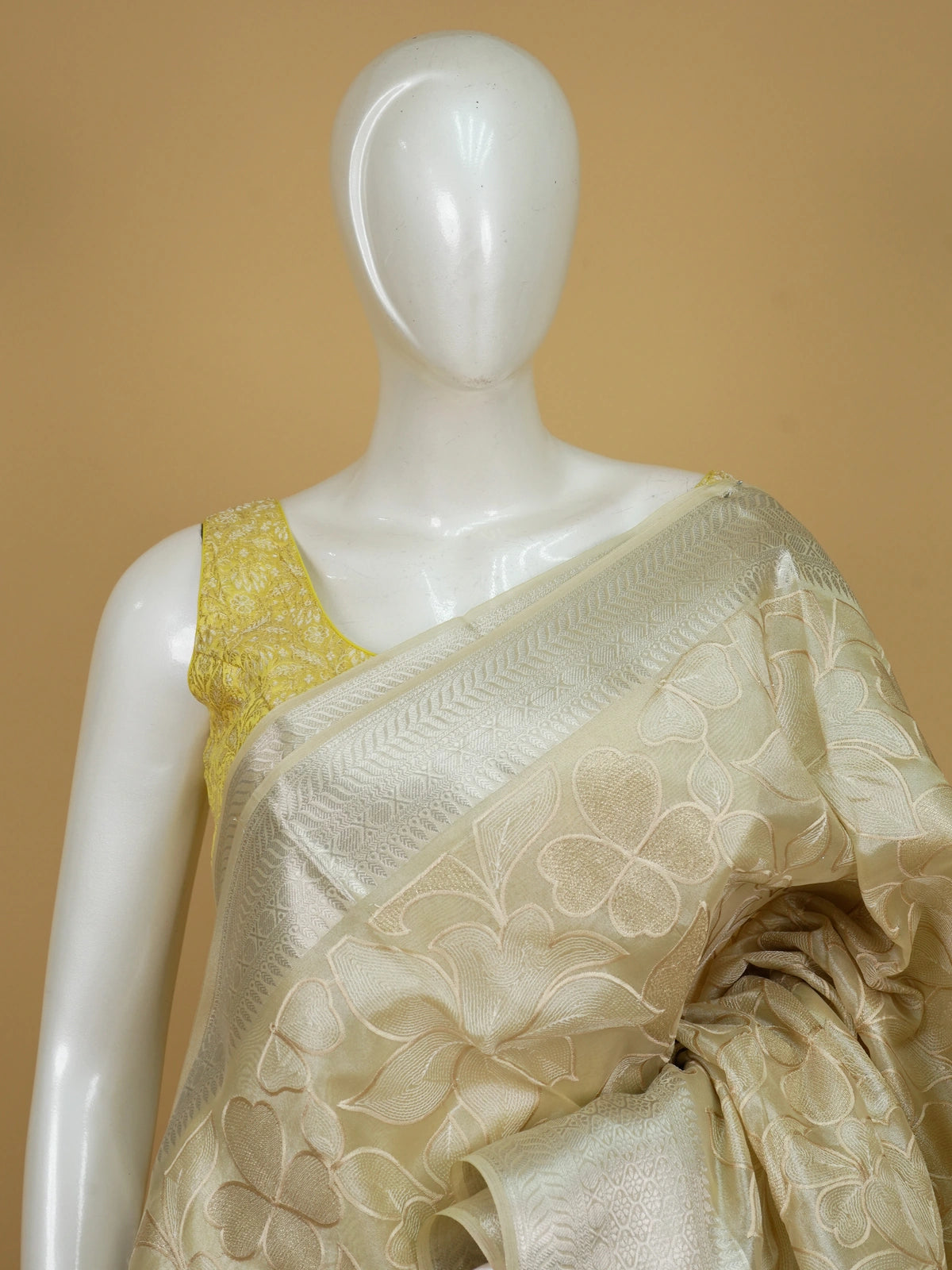 Cream tissue designer saree with floral embroidery and silver zari border