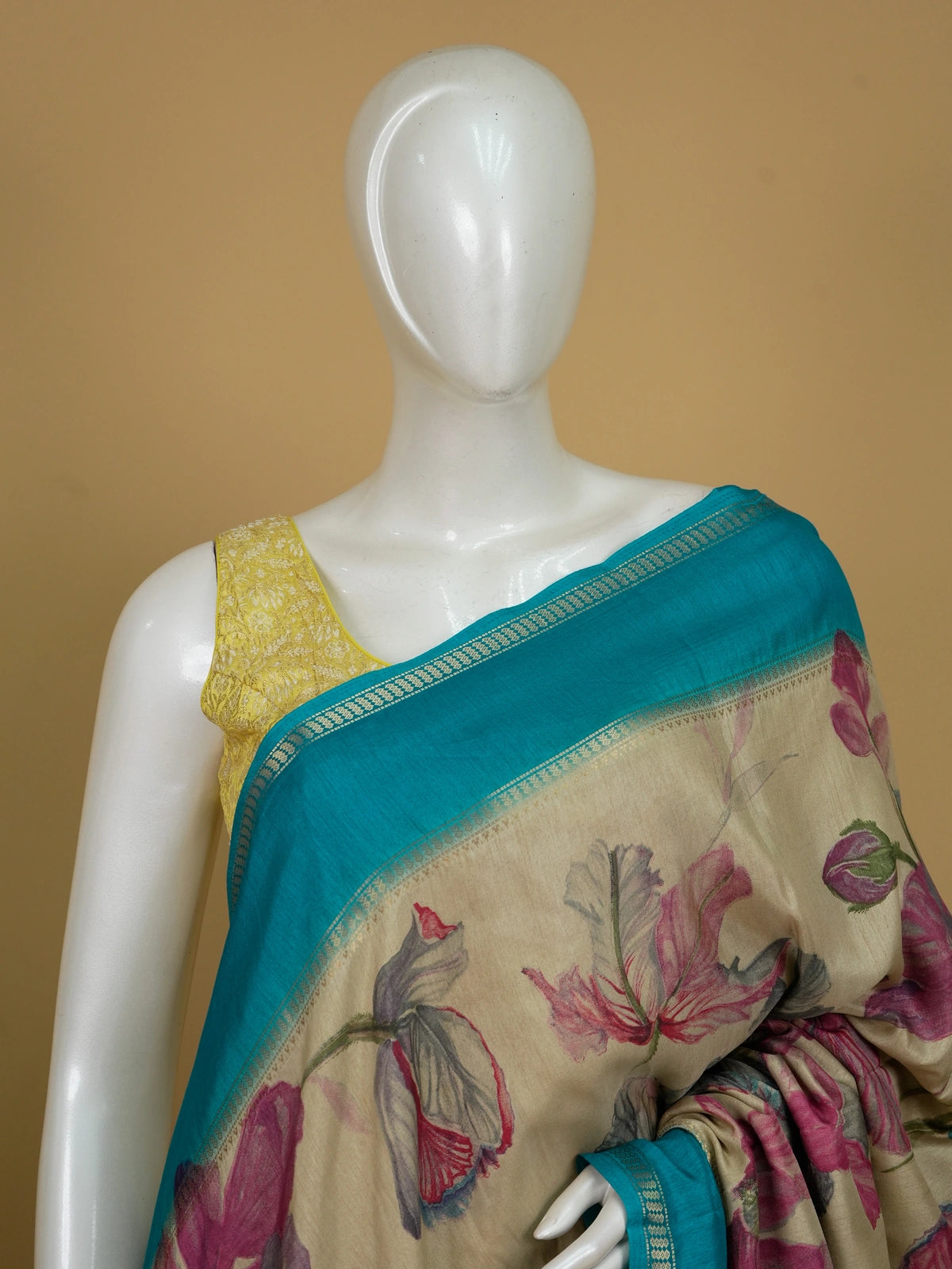 Beige Dola silk saree with pink and blue floral print and contrast teal zari border