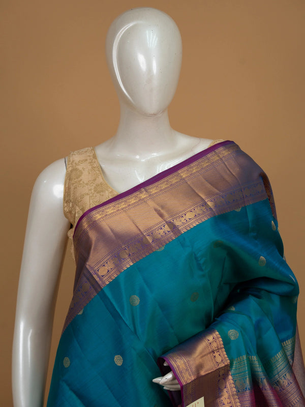Teal blue pure Kanchipuram silk saree with contrast magenta border and gold zari buttas