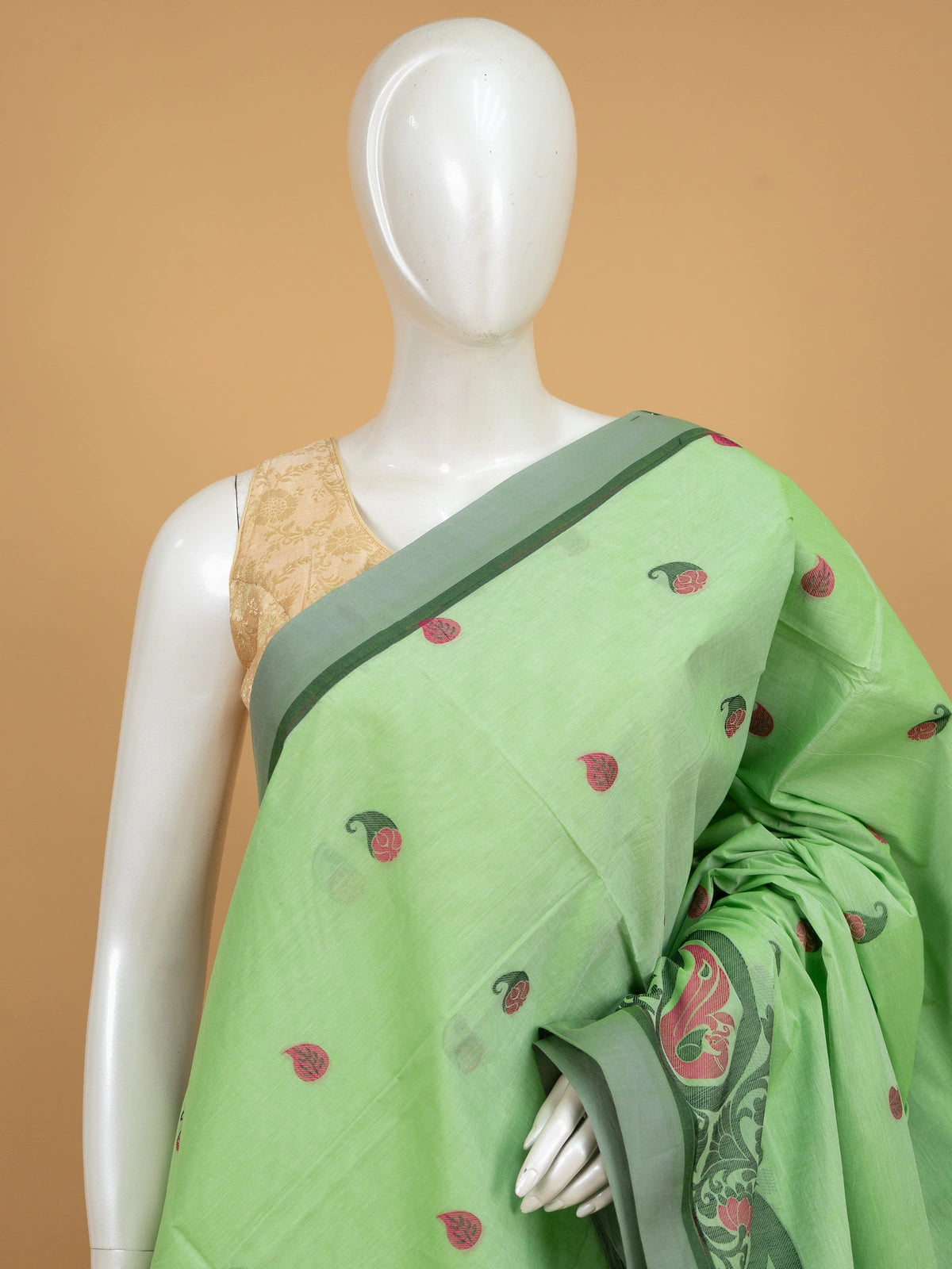 Light green silk cotton saree with pink paisley buttas, contrast grey-green border, and woven floral pallu