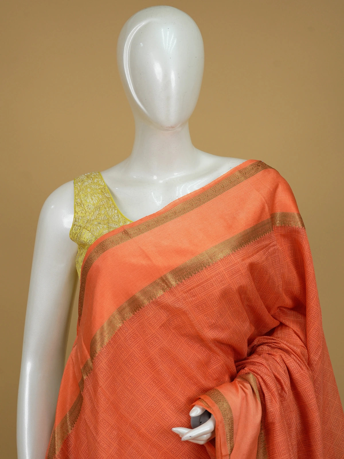 Orange semi tussar saree with gold zari border and geometric patterned body