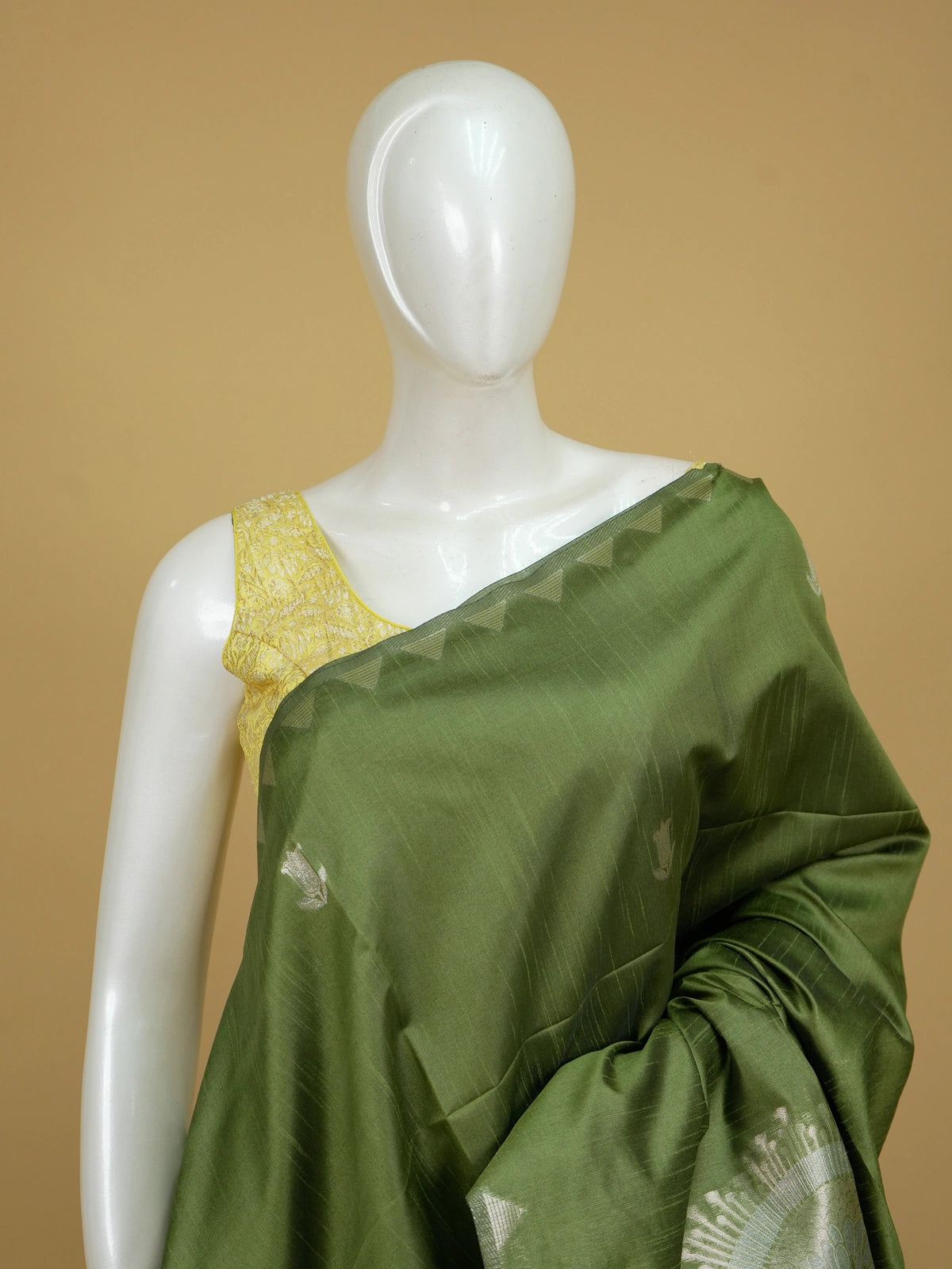 Olive green semi tussar saree with silver zari floral motifs and temple border