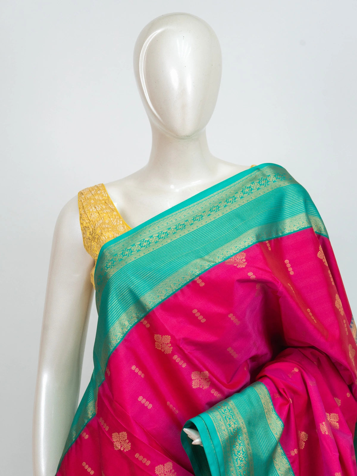 Rani pink Kanchipuram fancy silk saree with teal green contrast border, gold zari buttas and diamond-grid zari pallu