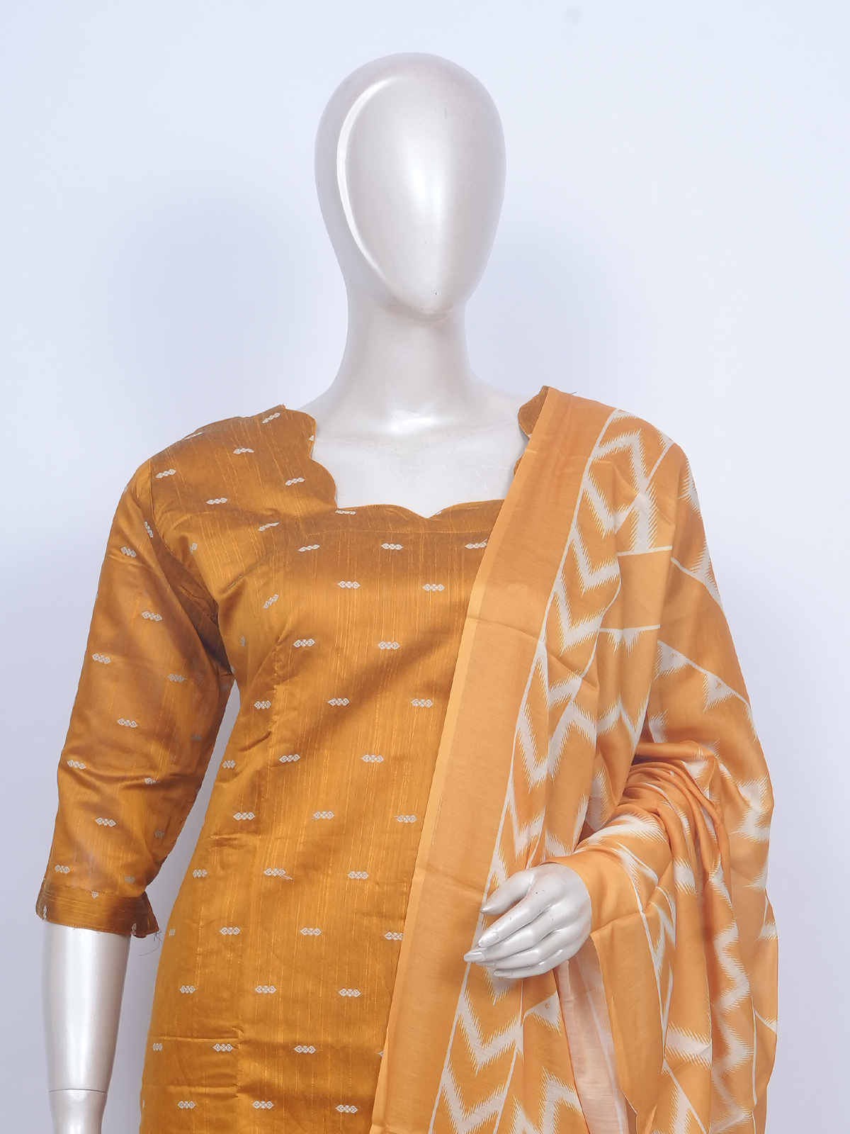 Mustard yellow woven buti kurti set with cream pants and ikat chevron print dupatta