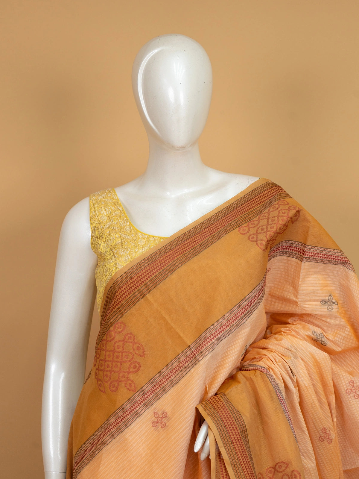 Peach and mustard semi raw silk saree with contrast border and kolam motif pallu