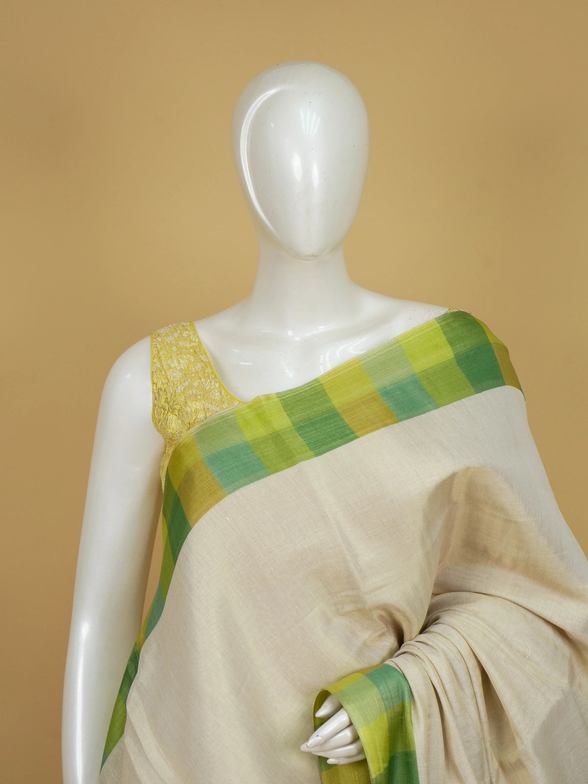 Cream linen cotton saree with green and yellow checked border and pallu